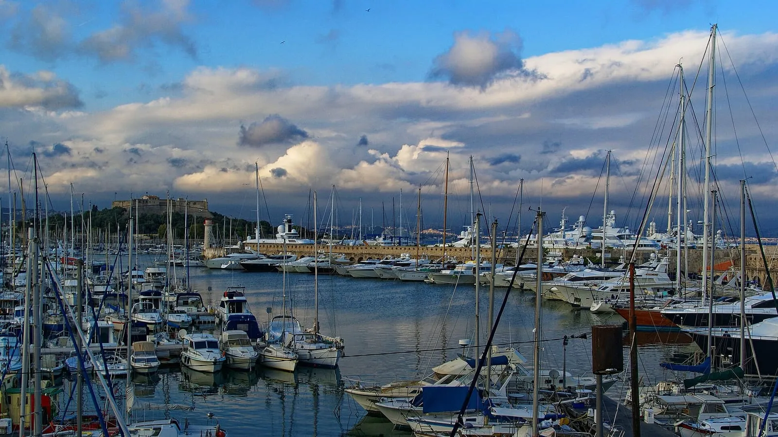 Le Port Vauban à Antibes, ses voiliers et yachts au mouillage, avec le Fort Carré et le phare en arrière-plan