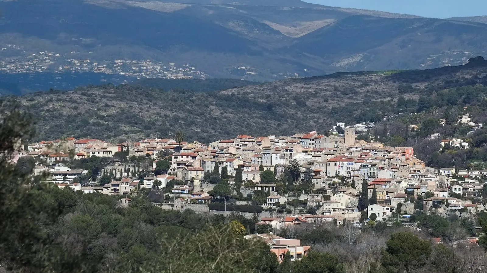 Le village de Biot à flanc de colline avec son clocher, adossé aux Préalpes d'Azur