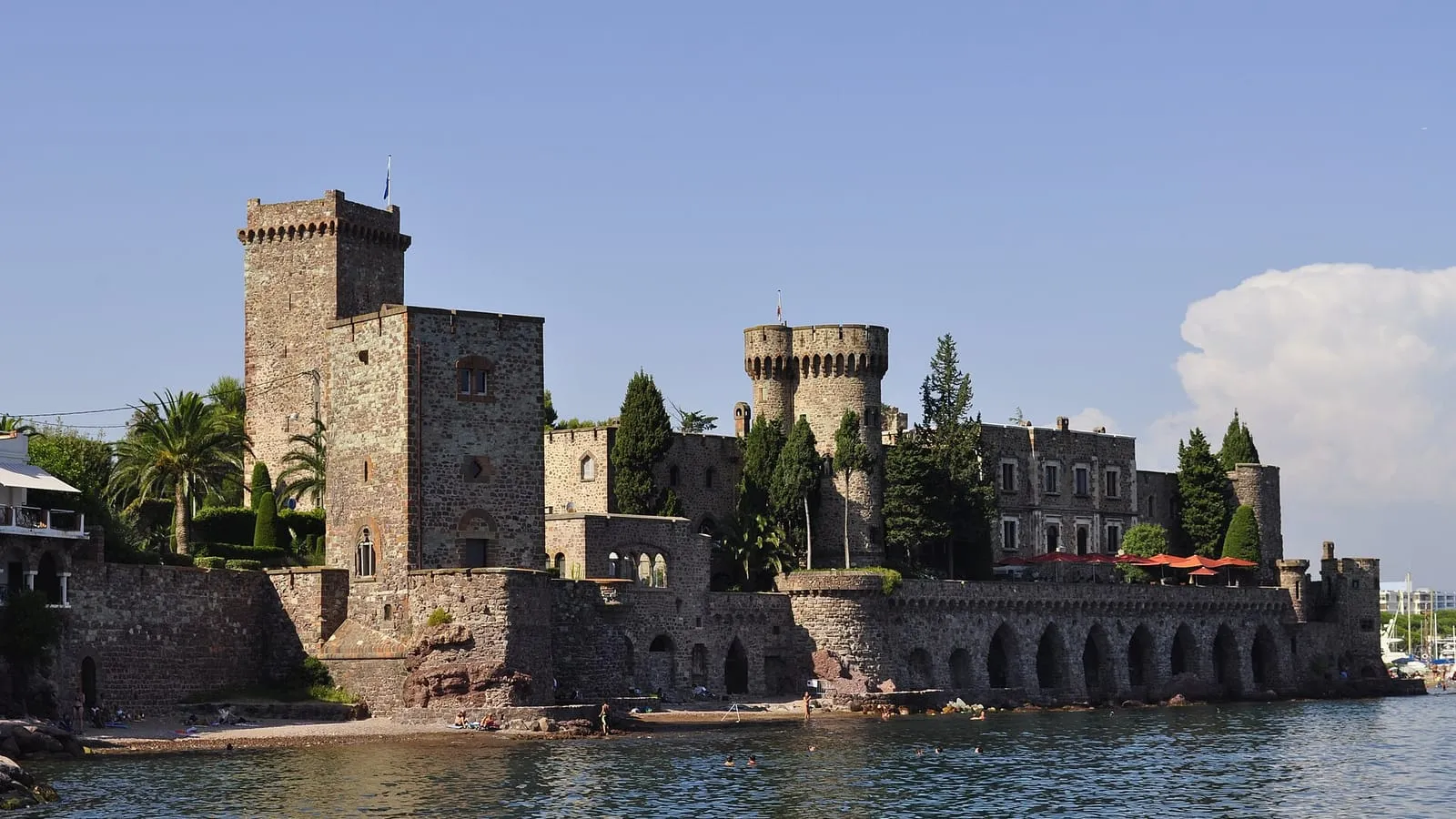 Le château de la Napoule et ses tours médiévales au bord de la Méditerranée, vus depuis la plage de la Raguette